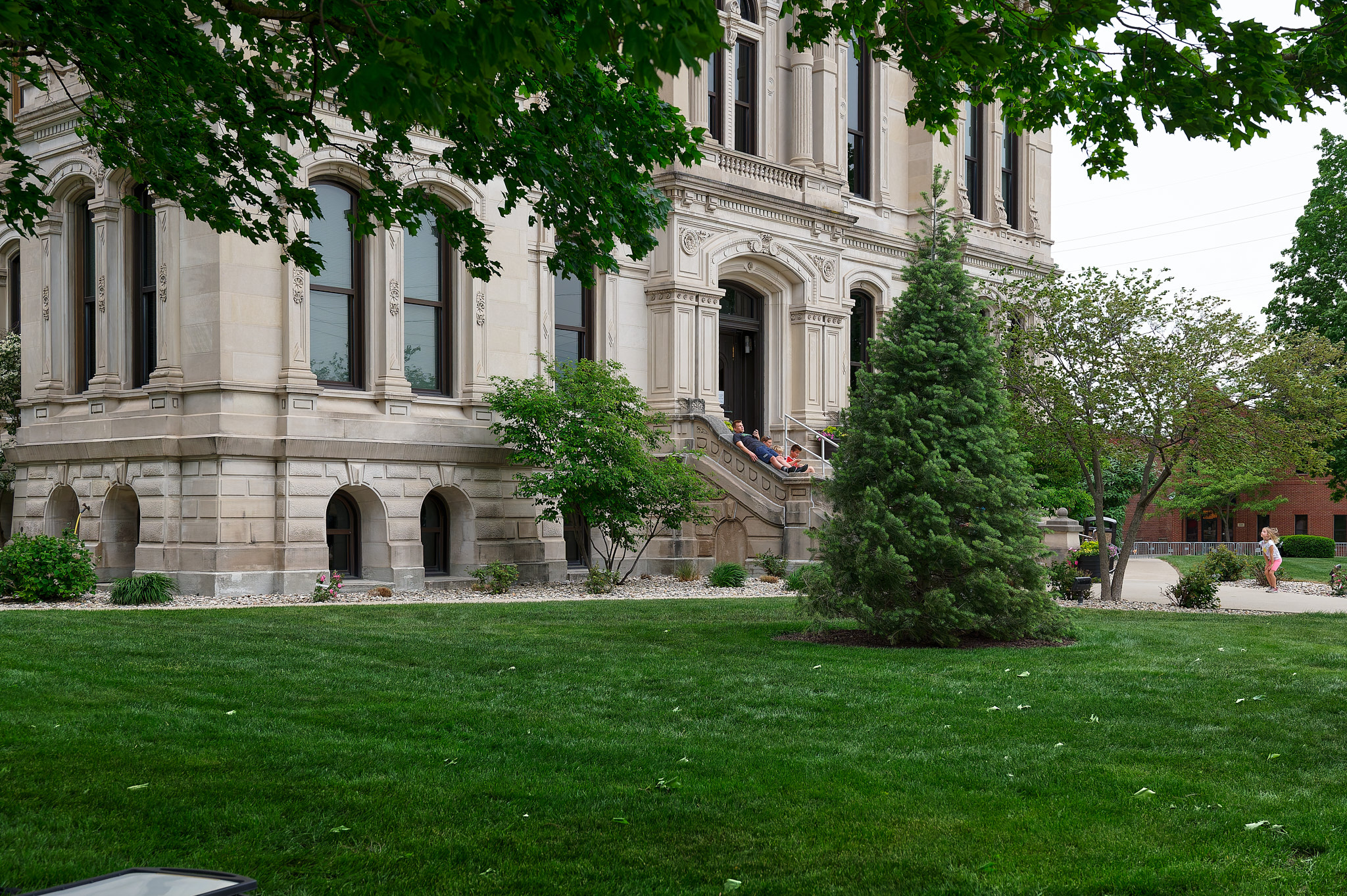 A family lounges on the steps of the courthouse.